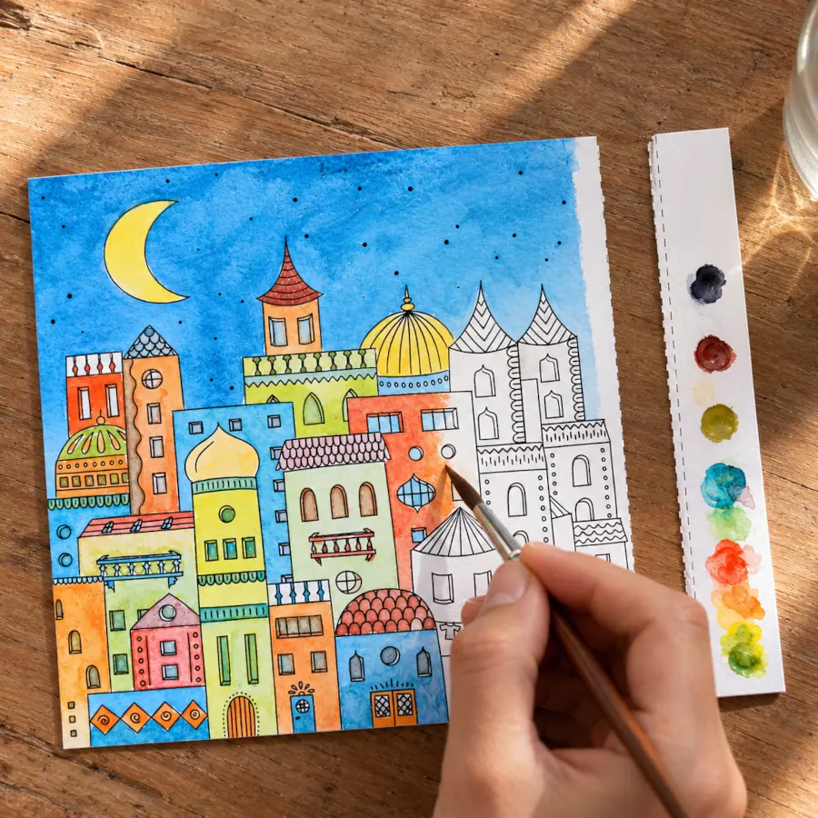 Carte à peindre en cours de mise en couleur à l'aquarelle naturelle, avec sa palette de pigments végétaux