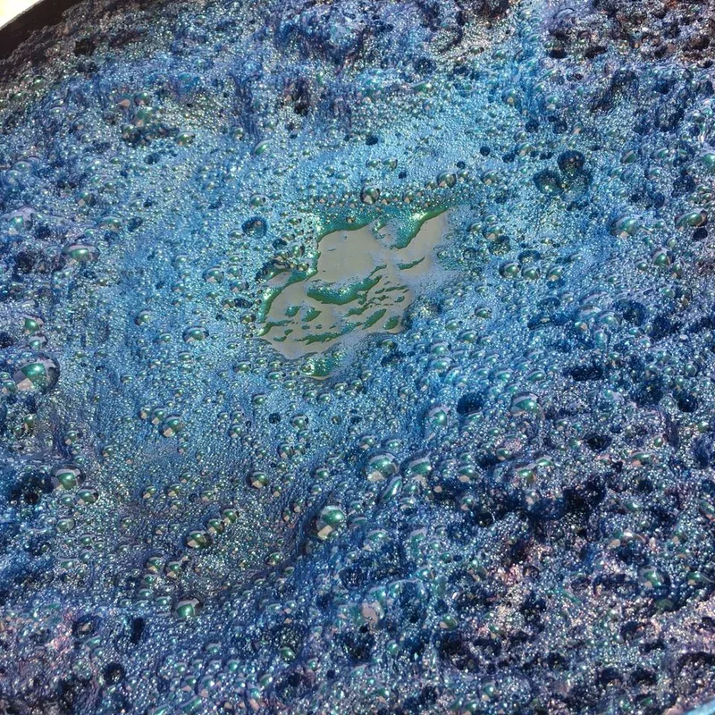 Surface d'une cuve d'indigo avec sa fleur cuivrée, teinture naturelle