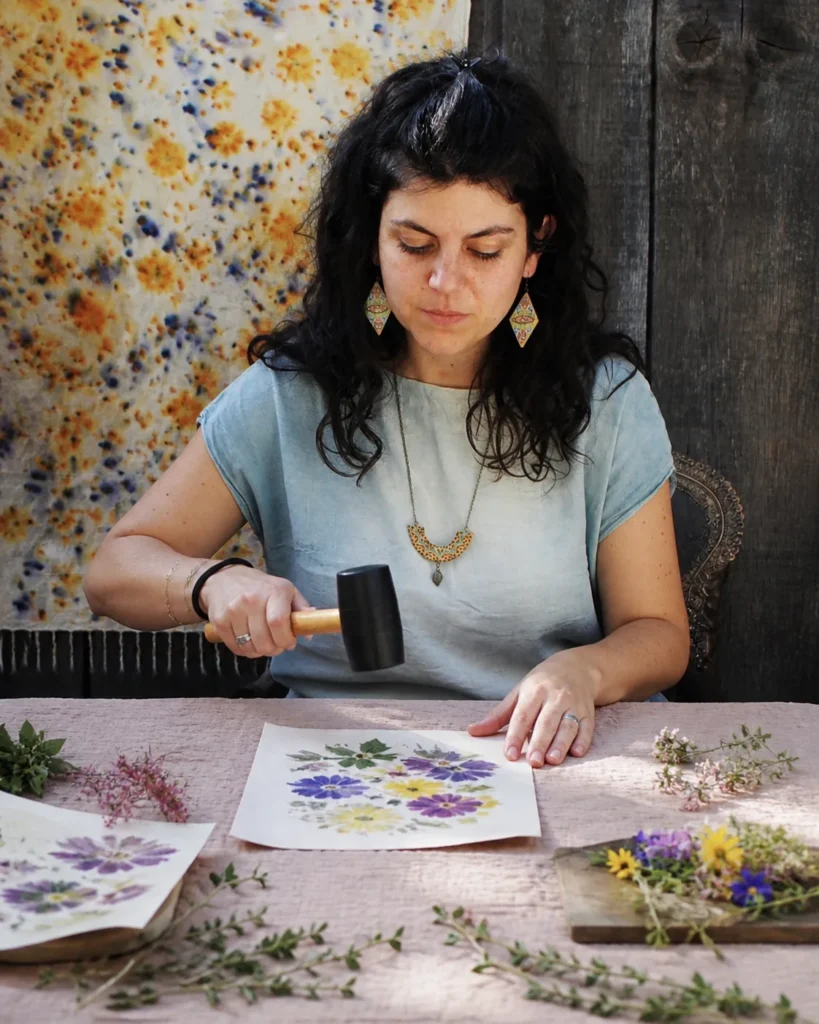 Meghan Milan martèle des fleurs sur une feuille de papier, technique du tatakizome, à l'atelier Tribu Indigo